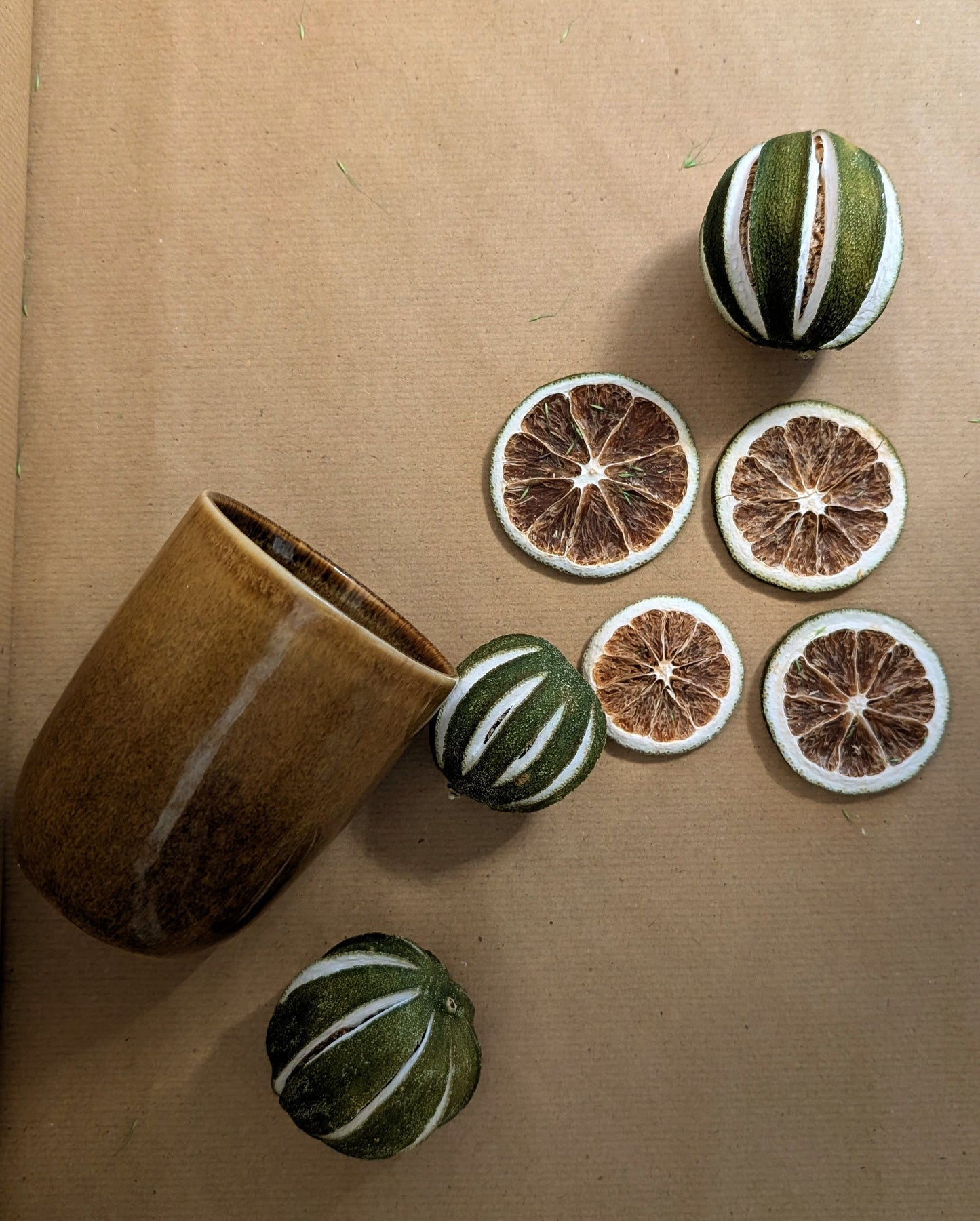 Decorative items including a ceramic cup and spherical and circular ornaments on a brown surface.