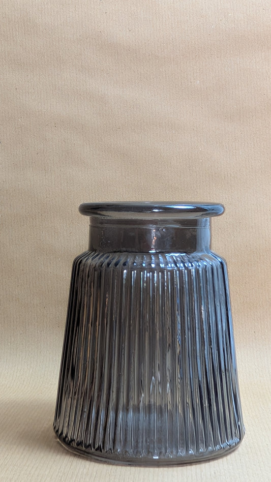 Grey ribbed glass vase on a beige background